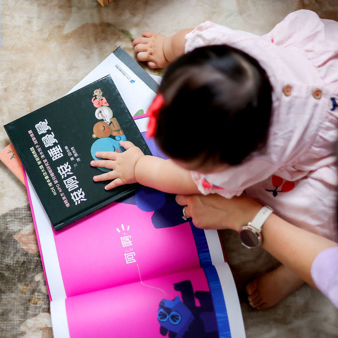 Child interacting with a book on a carpeted floor